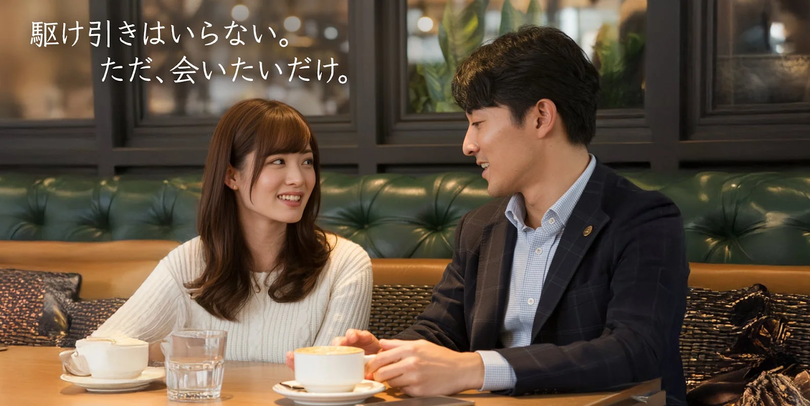 カフェで向かい合って座る男女が、笑顔で会話を楽しんでいる様子